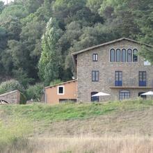 Masia de Can Riera de la Pineda envoltada de camps i bosc, a Arbúcies