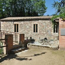 Edifici de pedra de la Farga del Roquer al costat de la riera d'Arbúcies