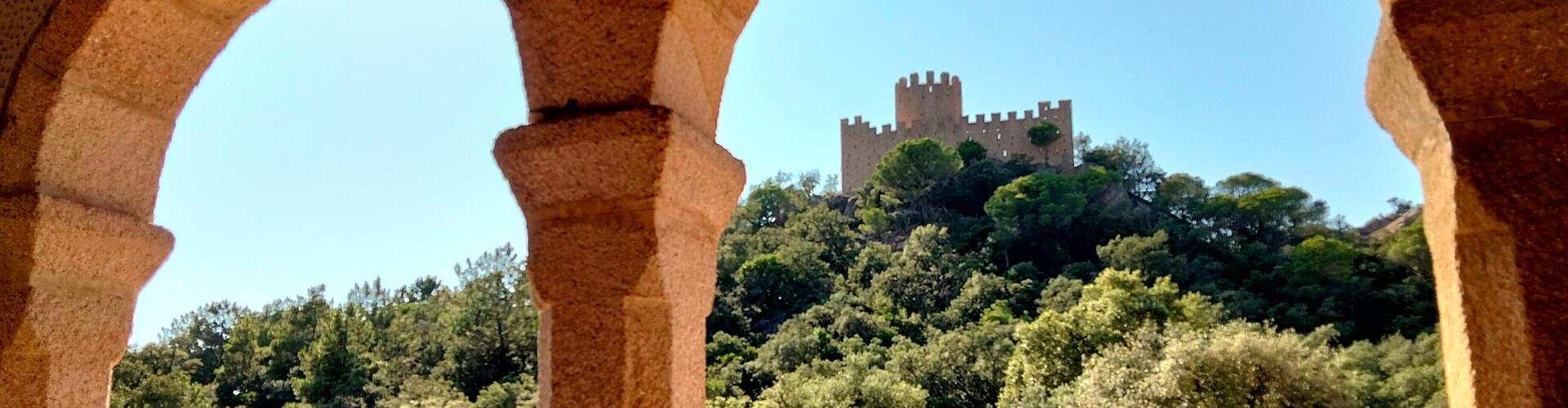 Castell de Farners vist entre les arcades del porxo del santuari, Santa Coloma de Farners